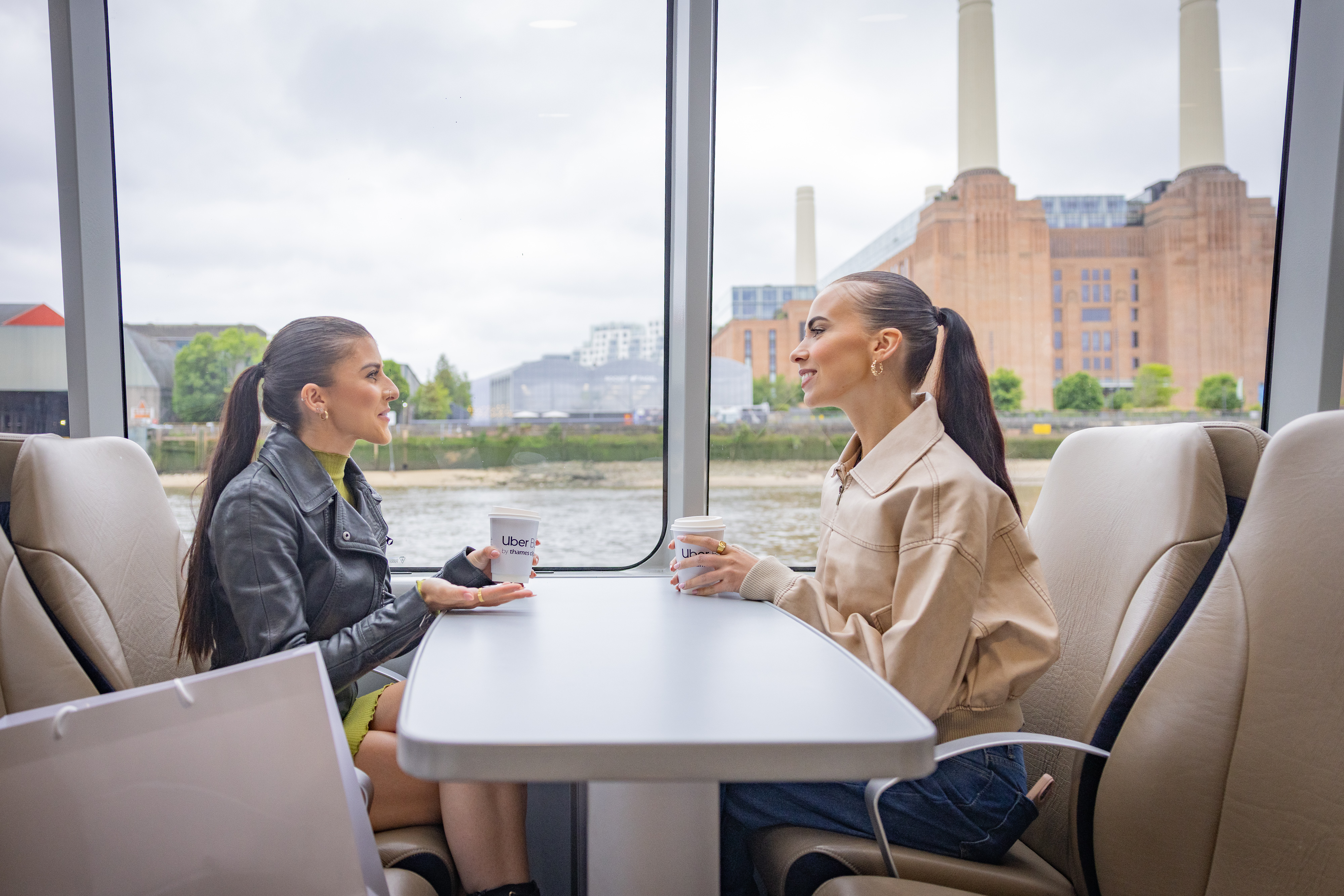 Girls on a boat chatting , battersea power station background
